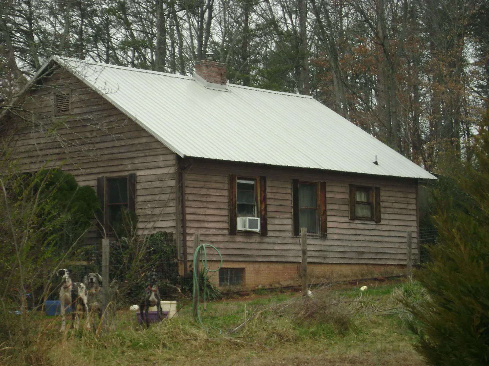 White metal roof on an old wood sided farmhouse, from a Metal Roof Installation job in Lafitte